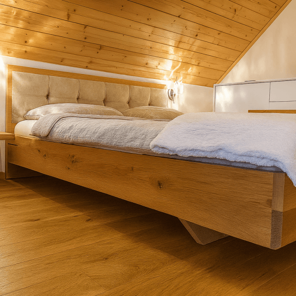 Ein modernes Bett aus Holz mit einem gepolsterten Kopfteil in einem Schlafzimmer mit Holzdecke.