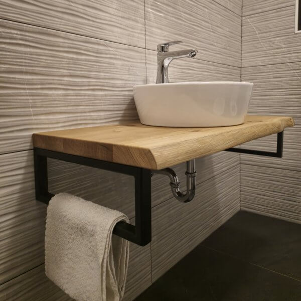 Moderne Holzwaschtisch mit einer weißen Schüssel und einem Handtuchhalter aus Metall.